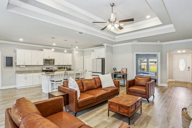 3291 Secret Isle Way, Navarre, FL 32566 - living area with light wood finished floors, ceiling fan, arched walkways, baseboards, and crown molding