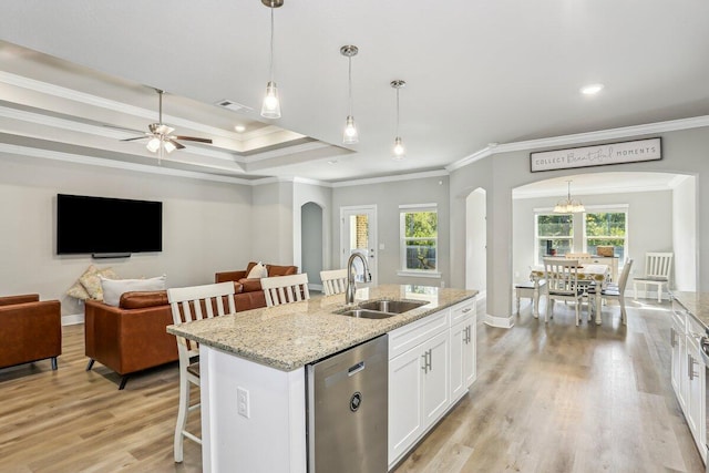 3291 Secret Isle Way, Navarre, FL 32566 - kitchen with a sink, arched walkways, stainless steel dishwasher, a kitchen bar, and white cabinetry