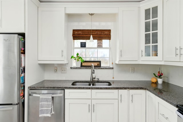 kitchen featuring tasteful backsplash, appliances with stainless steel finishes, white cabinetry, and a sink