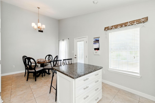 kitchen with baseboards, light tile patterned flooring, a chandelier, and white cabinetry