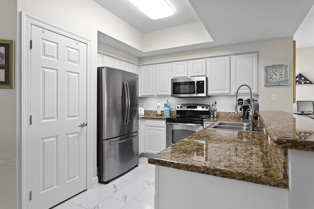 122 Seascape Dr Unit 701, Miramar Beach, FL 32550 - kitchen featuring a sink, appliances with stainless steel finishes, a peninsula, white cabinetry, and marble finish floor