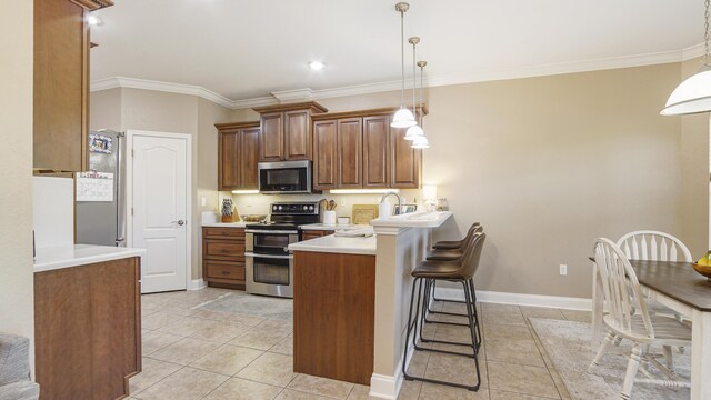 554 Magnolia Lake Dr, Defuniak Springs, FL 32433 - kitchen with stainless steel appliances, a peninsula, light tile patterned floors, a kitchen breakfast bar, and ornamental molding