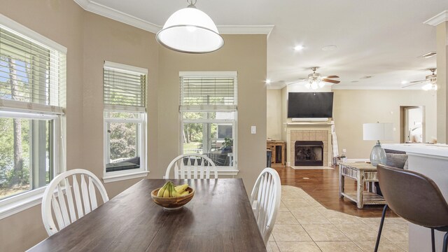 554 Magnolia Lake Dr, Defuniak Springs, FL 32433 - tiled dining area with a ceiling fan, ornamental molding, and a tile fireplace
