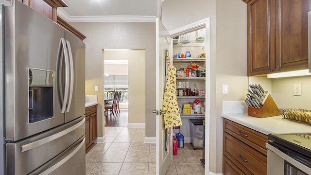 554 Magnolia Lake Dr, Defuniak Springs, FL 32433 - kitchen with stainless steel fridge, light tile patterned floors, light countertops, and crown molding