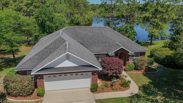 554 Magnolia Lake Dr, Defuniak Springs, FL 32433 - view of front of house featuring roof with shingles, brick siding, a garage, a water view, and driveway