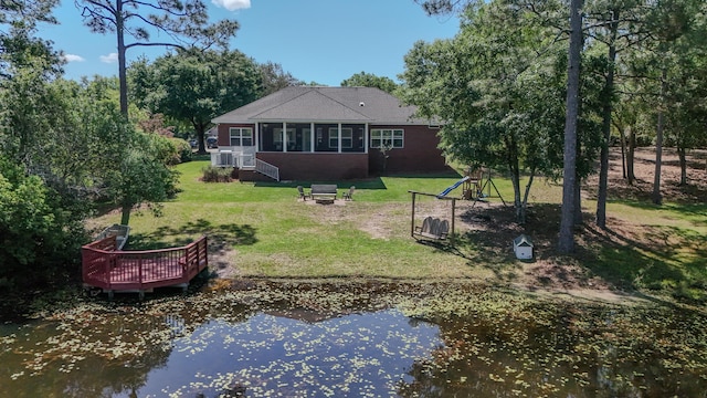 554 Magnolia Lake Dr, Defuniak Springs, FL 32433 - rear view of house featuring a water view, a lawn, and a sunroom