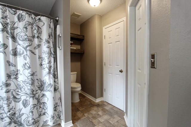 206 Secretariat Dr, Crestview, FL 32539 - full bathroom with a shower with curtain, a textured ceiling, visible vents, toilet, and stone tile flooring
