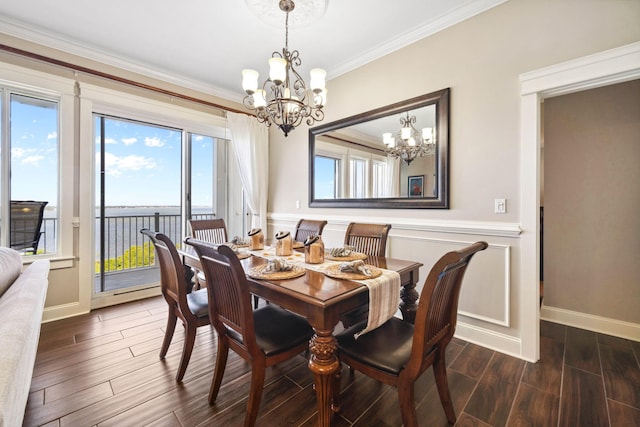 dining space with a chandelier, dark wood-style floors, crown molding, baseboards, and wainscoting