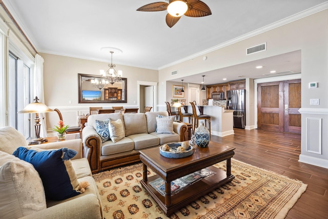 living room with crown molding, a chandelier, ceiling fan, and wood finished floors