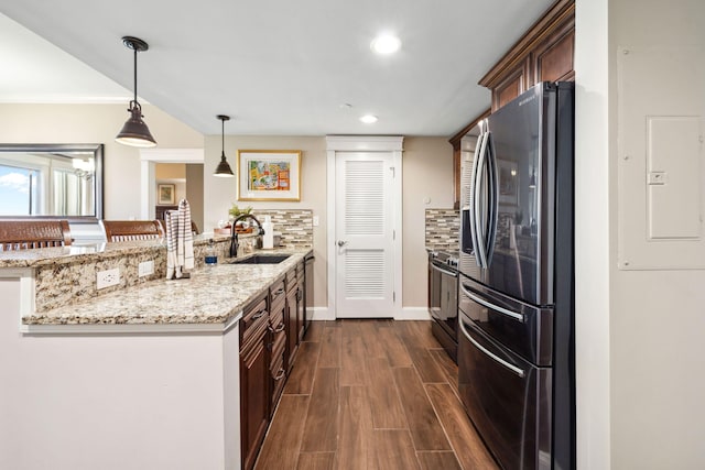 kitchen featuring appliances with stainless steel finishes, a sink, a peninsula, electric panel, and dark wood-style flooring