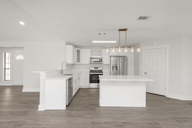 197 Kel-Wen Circle Kel-Wen, Destin, FL 32541 - kitchen featuring appliances with stainless steel finishes, a sink, backsplash, a kitchen island, and light countertops