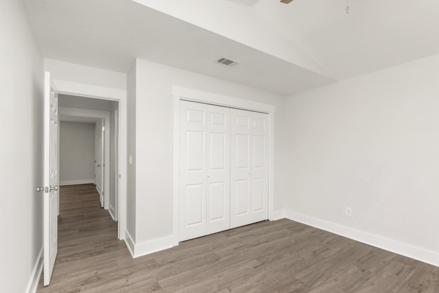 197 Kel-Wen Circle Kel-Wen, Destin, FL 32541 - unfurnished bedroom with light wood-style floors, baseboards, lofted ceiling, and a closet