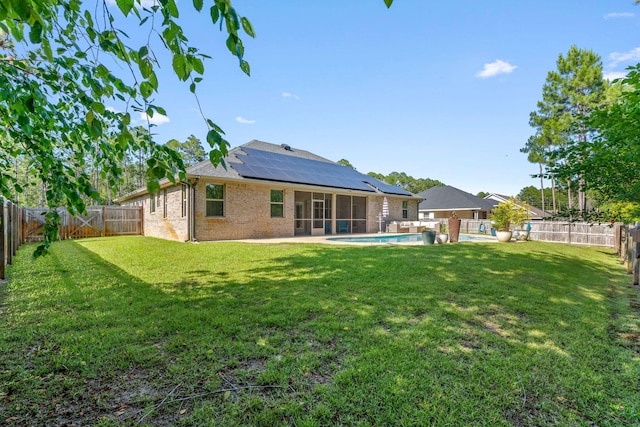 7045 Leisure St, Navarre, FL 32566 - back of house with a sunroom, solar panels, and brick siding