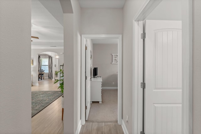 7045 Leisure St, Navarre, FL 32566 - corridor featuring arched walkways, wood finished floors, baseboards, and ornamental molding