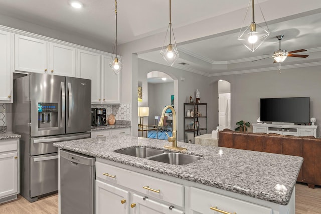 7045 Leisure St, Navarre, FL 32566 - kitchen featuring arched walkways, a sink, stainless steel appliances, open floor plan, and ceiling fan