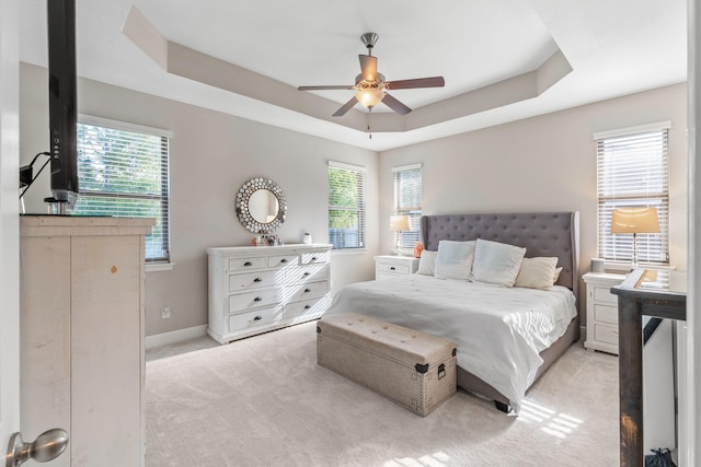 7045 Leisure St, Navarre, FL 32566 - carpeted bedroom with multiple windows, a tray ceiling, baseboards, and ceiling fan