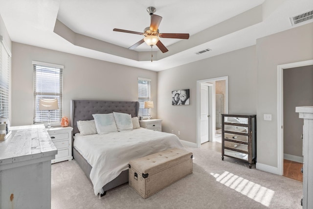 7045 Leisure St, Navarre, FL 32566 - bedroom featuring multiple windows, a tray ceiling, light colored carpet, and baseboards