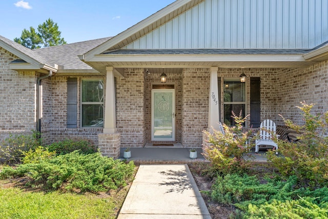 7045 Leisure St, Navarre, FL 32566 - view of exterior entry featuring brick siding, a porch, and board and batten siding