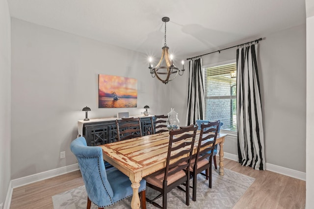 7045 Leisure St, Navarre, FL 32566 - dining room featuring a chandelier, wood finished floors, and baseboards