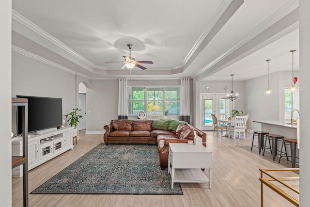 7045 Leisure St, Navarre, FL 32566 - living area featuring a tray ceiling, ceiling fan, wood finished floors, arched walkways, and ornamental molding