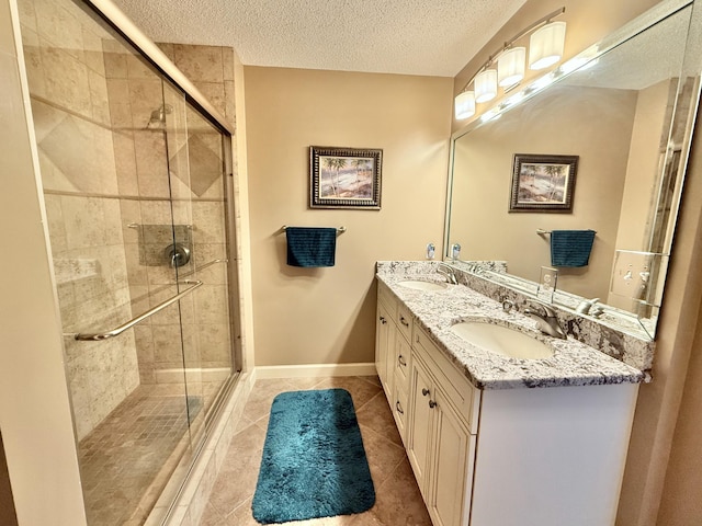 full bath with tile patterned floors, a textured ceiling, a stall shower, and a sink