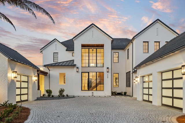 724 Windsong Dr, Inlet Beach, FL 32461 - back of property at dusk with a garage, a standing seam roof, metal roof, and decorative driveway