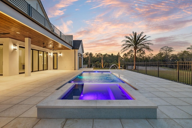 724 Windsong Dr, Inlet Beach, FL 32461 - pool at dusk featuring a fenced in pool, an in ground hot tub, fence, a ceiling fan, and a patio