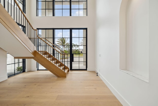 724 Windsong Dr, Inlet Beach, FL 32461 - foyer featuring baseboards, wood finished floors, a high ceiling, and stairway