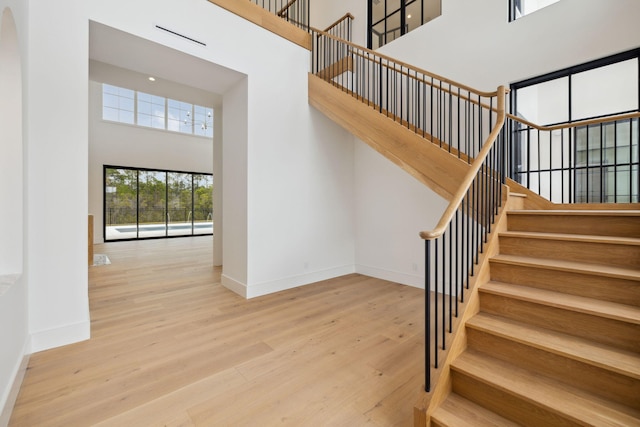 724 Windsong Dr, Inlet Beach, FL 32461 - stairs with wood finished floors, a high ceiling, and baseboards