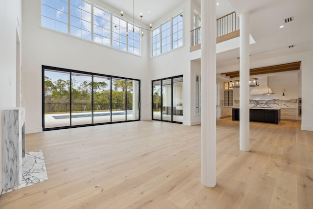724 Windsong Dr, Inlet Beach, FL 32461 - unfurnished living room with a high ceiling, light wood-style floors, visible vents, and baseboards