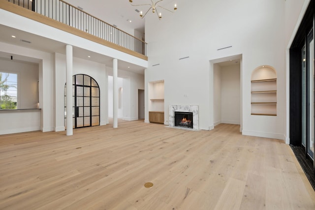 724 Windsong Dr, Inlet Beach, FL 32461 - unfurnished living room featuring baseboards, visible vents, a premium fireplace, wood finished floors, and a high ceiling