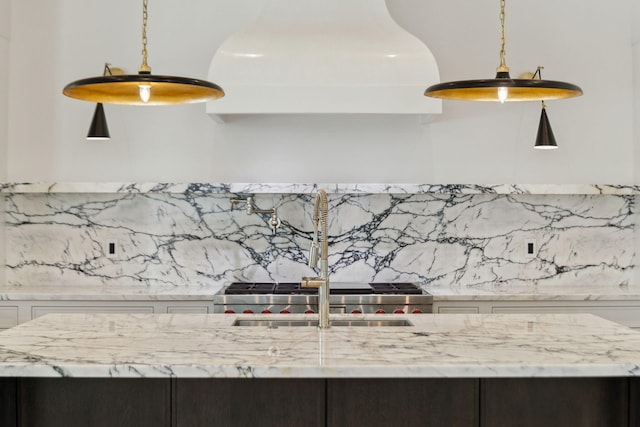 724 Windsong Dr, Inlet Beach, FL 32461 - interior details featuring decorative backsplash, white cabinetry, light stone counters, and hanging light fixtures