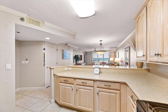 kitchen with light brown cabinetry, light countertops, visible vents, ornamental molding, and a peninsula