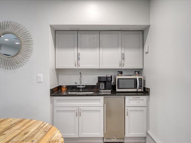 4214 Beachside Two Dr # 214, Miramar Beach, FL 32550 - kitchen with stainless steel appliances, a sink, dark stone countertops, and white cabinetry