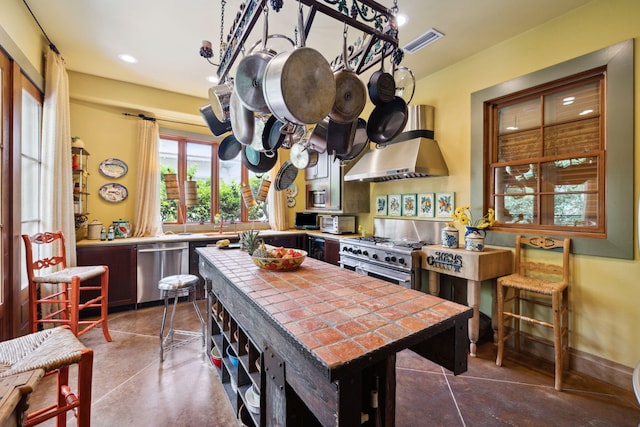 30 Place De La Fontaine, Miramar Beach, FL 32550 - kitchen with recessed lighting, tile counters, stainless steel appliances, wall chimney exhaust hood, and visible vents