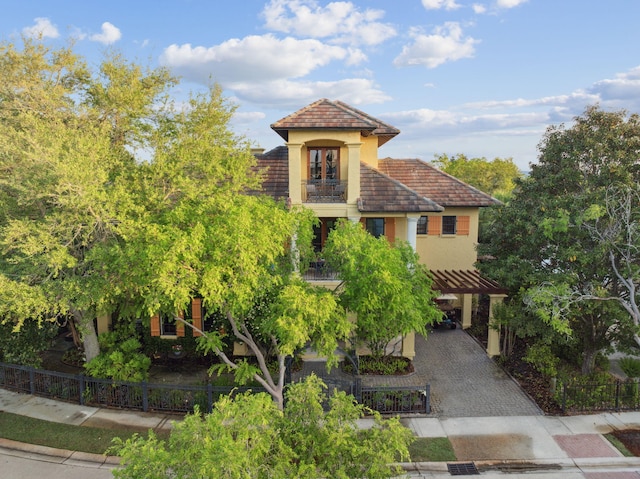 30 Place De La Fontaine, Miramar Beach, FL 32550 - mediterranean / spanish home featuring decorative driveway, stucco siding, a fenced front yard, and a balcony