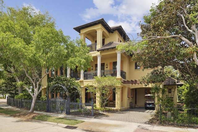 30 Place De La Fontaine, Miramar Beach, FL 32550 - view of front of property featuring stucco siding, fence private yard, decorative driveway, a tile roof, and a balcony