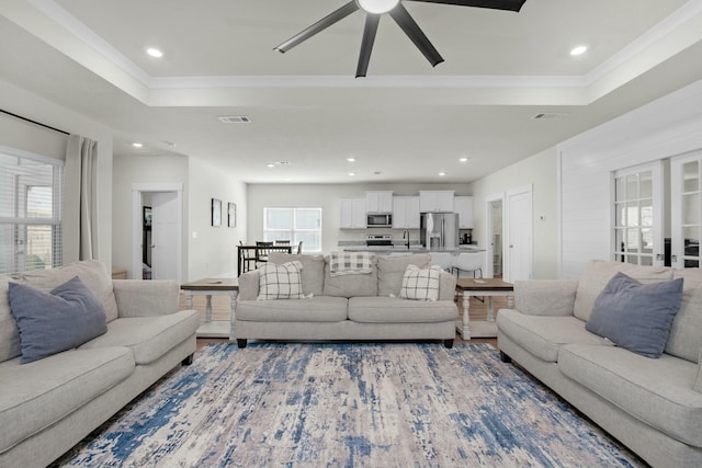 living area with crown molding, recessed lighting, plenty of natural light, and a ceiling fan