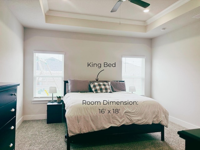 carpeted bedroom with a raised ceiling, ornamental molding, baseboards, and a ceiling fan