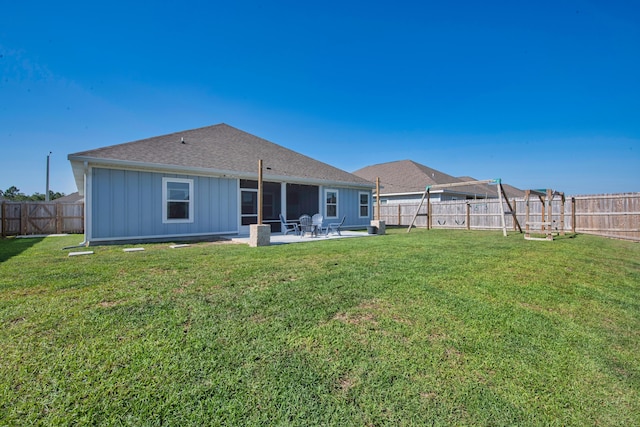 back of property with board and batten siding, a patio area, a shingled roof, and a sunroom