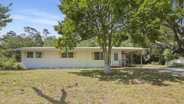 single story home featuring driveway, a carport, and a front yard