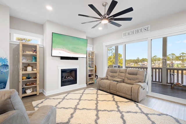 living room with baseboards, recessed lighting, wood finished floors, ceiling fan, and a fireplace