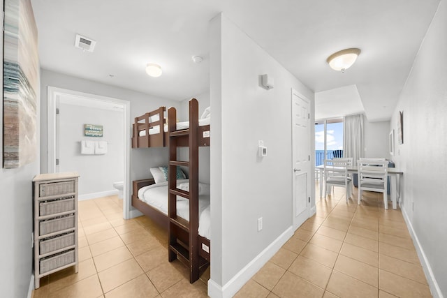 16819 Front Beach Rd Unit 1110, Panama City Beach, FL 32413 - bedroom featuring ensuite bath, light tile patterned flooring, baseboards, and visible vents
