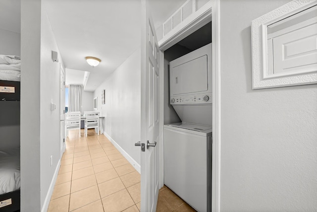 16819 Front Beach Rd Unit 1110, Panama City Beach, FL 32413 - laundry area with stacked washer and clothes dryer, light tile patterned floors, laundry area, visible vents, and baseboards