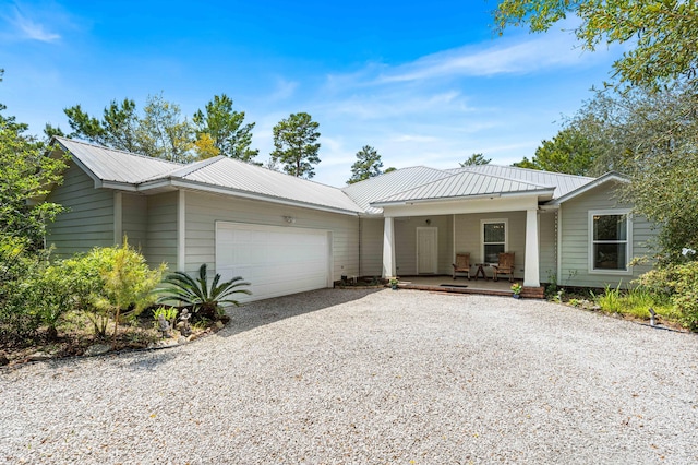 135 Bayou Point Dr, Santa Rosa Beach, FL 32459 - ranch-style home with covered porch, an attached garage, gravel driveway, and metal roof