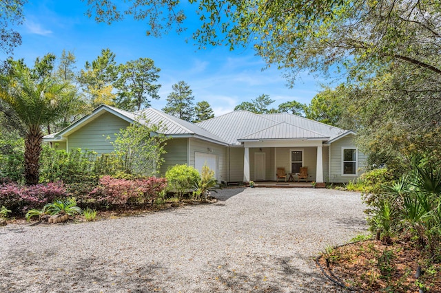 135 Bayou Point Dr, Santa Rosa Beach, FL 32459 - single story home with a garage, a porch, metal roof, and gravel driveway