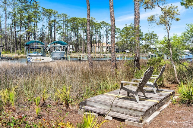 135 Bayou Point Dr, Santa Rosa Beach, FL 32459 - wooden terrace featuring boat lift, a water view, and a dock