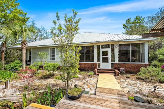 135 Bayou Point Dr, Santa Rosa Beach, FL 32459 - back of property with brick siding, a sunroom, and metal roof