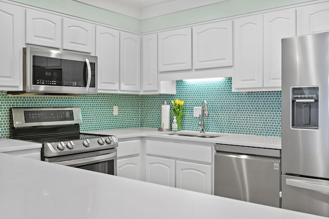 kitchen featuring white cabinets, appliances with stainless steel finishes, a sink, and light countertops