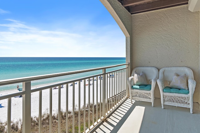 balcony with a beach view and a water view